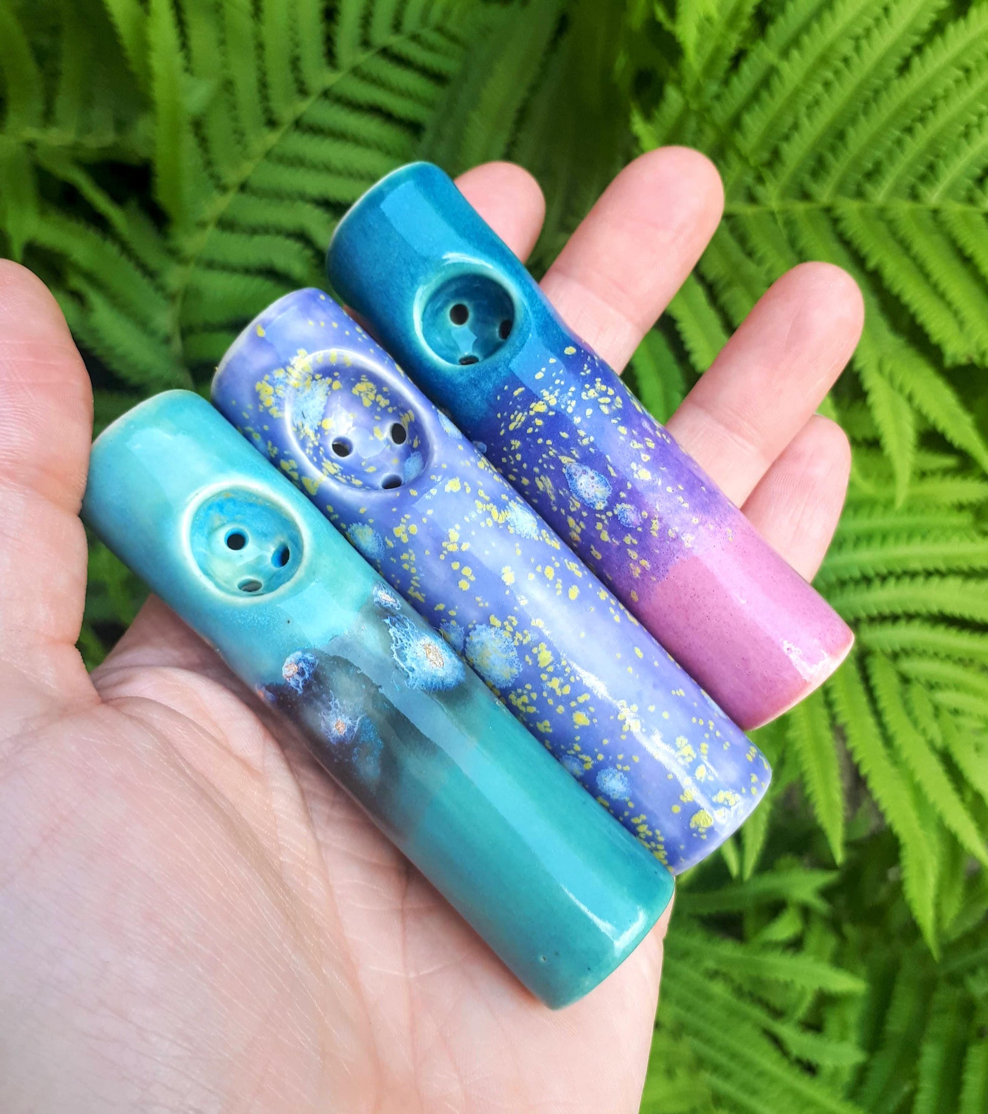 Dream collection mini purse cannabis pipes on hand in front of ferns